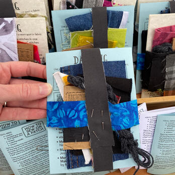 mending kits held together with thin fabric strips held in place with pins