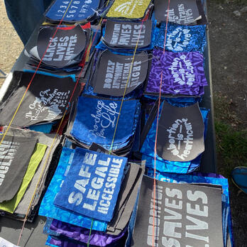 mending kits tied up in yellow yarn, with zines, thread, yarn, needle, fabric pieces