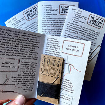 patch sewing kits with mini-zines, black thread, and needle