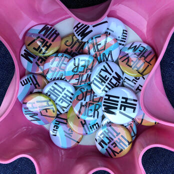 pronoun pins in a pink 7" record bowl shown from top down