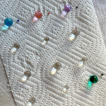 photo of 12 different water beads, soaked and dry side by side on a paper towel