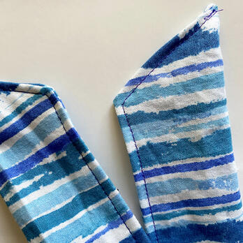 the ends of a cooling scarf, pointed, with top stitching going from the points down to the turn, and along the edge of the scarf