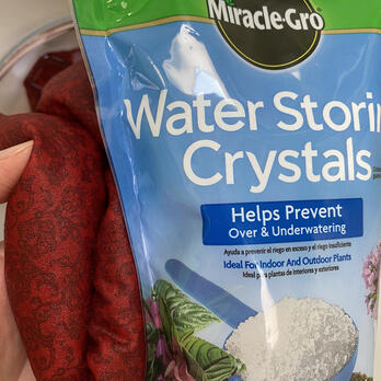 a soaked cooling scarf next to a bag of water storing crystals